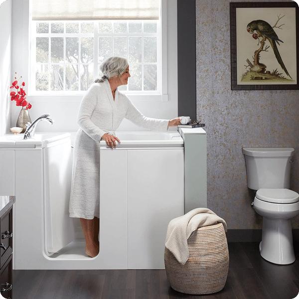 Seniorin in ihrem barrierefreien Bad mit begehbarer Badewanne und Haltegriffen für mehr Sicherheit und Unabhängigkeit.