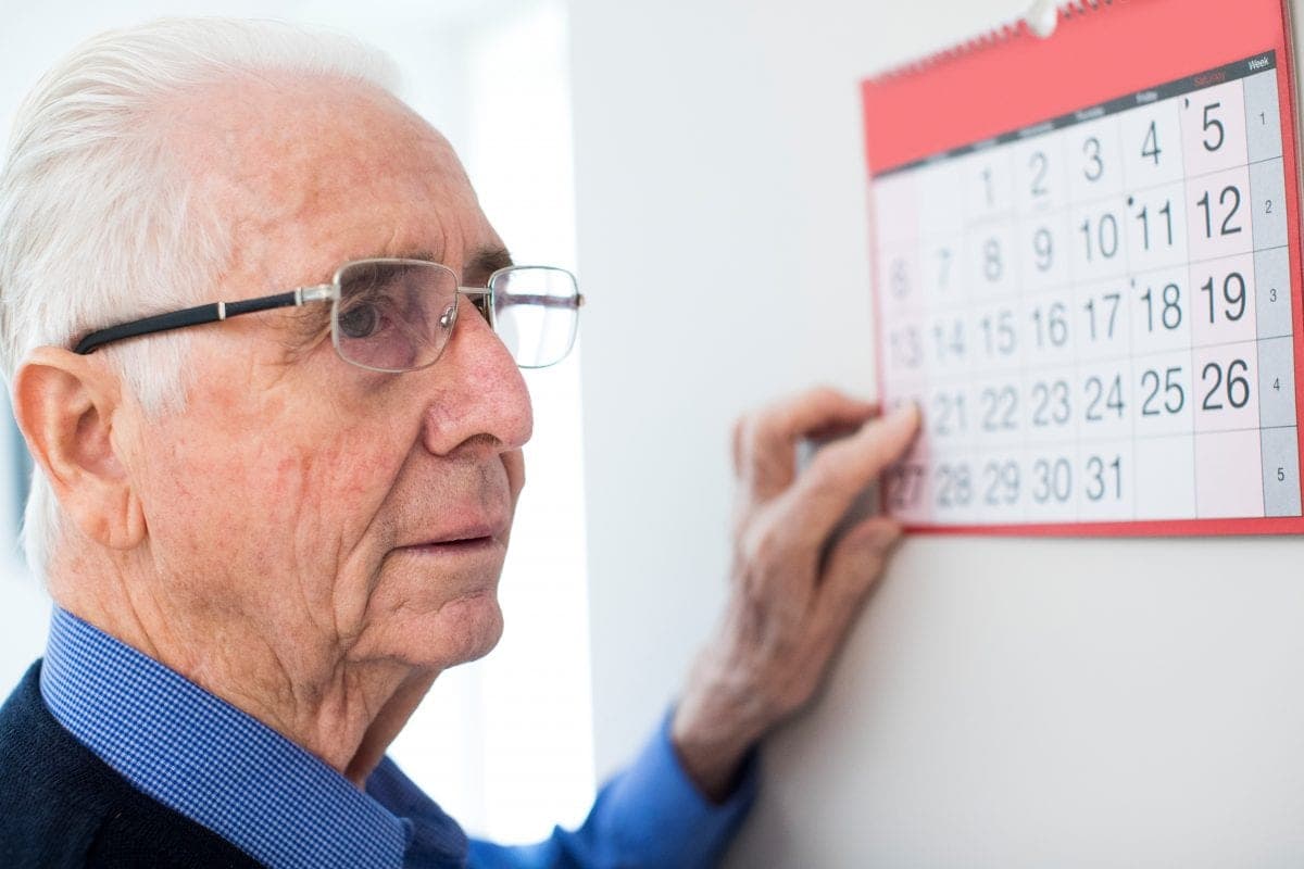 Älterer Mann blickt auf einen Wandkalender – der Stichtag 1. Januar 2027 der Pflegereform teilt Pflegebedürftige in zwei Klassen