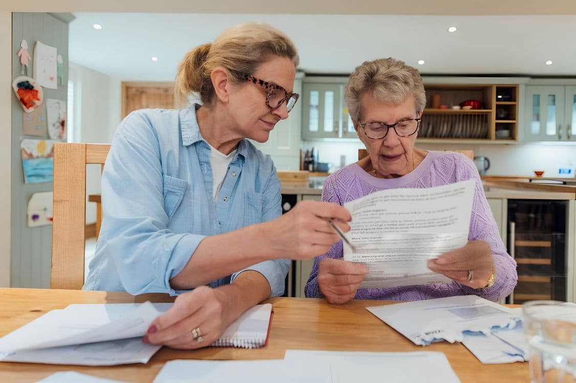 Pflegebedürftige Person liest Bescheid der Pflegekasse – Pflegereform 2026 setzt Pflegegrade unter Druck