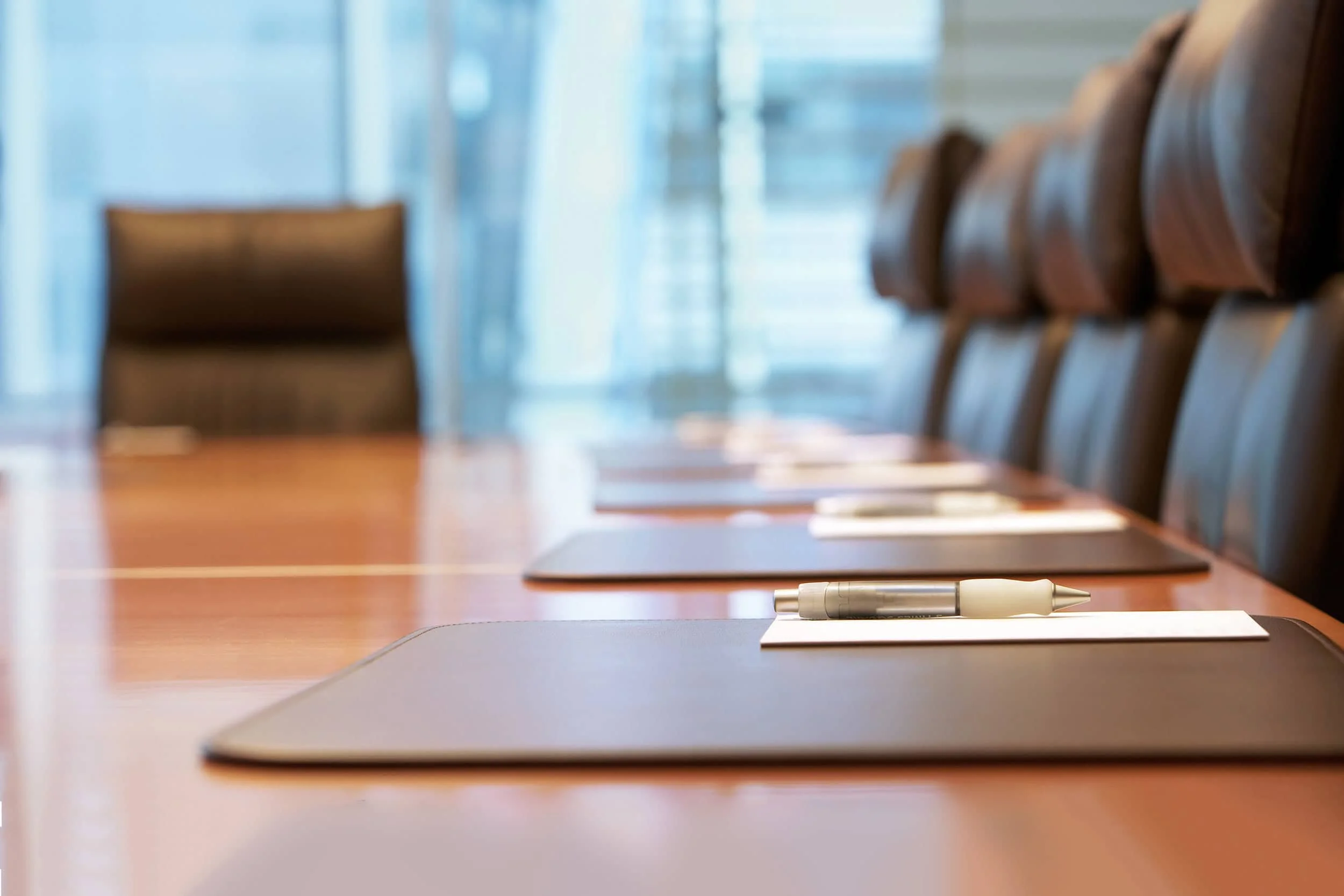 Leerer Konferenztisch mit unbenutzten Schreibmappen und Stiften – der Vorschlag des Wirtschaftsrats zur Pflegefinanzierung ist eingereicht, aber noch nicht entschieden