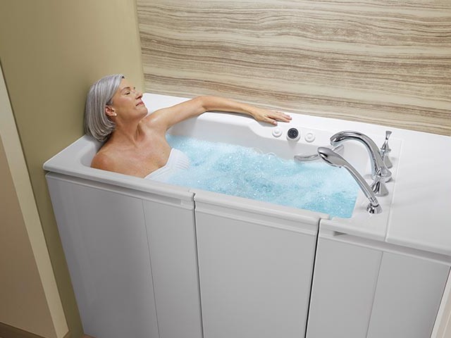 Frau entspannt in einer Badewanne mit Tür